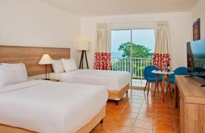 普拉亚布兰卡Grand Decameron Panama, A Trademark All Inclusive Resort的酒店客房设有两张床和一个阳台。