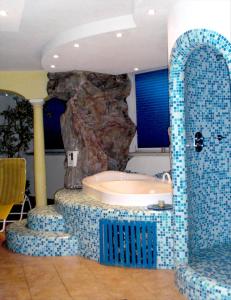 卡里索洛阿尔伯格加尔尼玛蒂娜酒店的岩石前带浴缸的浴室