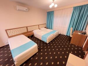 胡内多阿拉Hostel Paltinis的酒店客房配有两张床和一张书桌