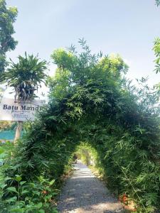 武吉拉旺Wisma Batu Mandi Trekking only的花园中种有树木和道路的拱门