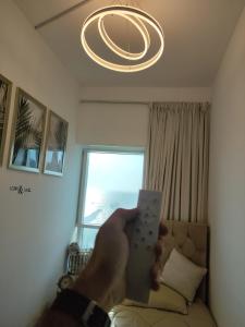 阿吉曼Cozy Small Private Room Sea View window的在一个房间里拥有Wii遥控器的人