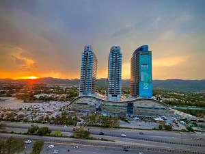 伊斯兰堡Elysium Skyline View Apartments Facing Centaurus mall Islamabad的落日时,在城市里一群高耸的摩天大楼