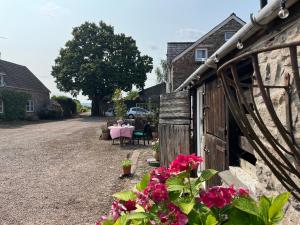 阿斯克Cosy Stable at Oak Farm的车道上带桌子和鲜花的房子