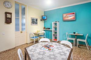 巴达洛纳索里玛尔旅馆的配有桌椅和蓝色墙壁的客房
