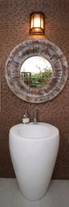 尼格瑞尔桑迪天堂度假村的浴室设有白色水槽和镜子