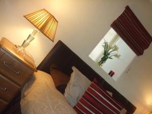 洛西茅斯Links Lodge的一间卧室配有床、灯和窗户