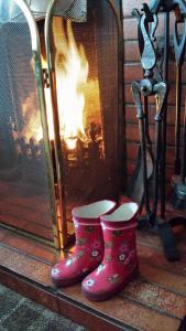 洛西茅斯Links Lodge的壁炉旁的一双粉红色靴子