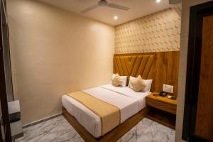 孟买HOTEL BKC PRIME - NEAR US CONSULATE的一间卧室配有一张大床和木制床头板