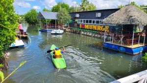 Munroe IslandBell Farms and Resorts的建筑物旁边的水中划皮艇的人