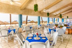 伊斯塔帕波萨达皇家伊斯塔帕酒店的一间设有蓝色桌子和白色椅子的餐厅