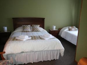 蓬塔阿雷纳斯VALYAK rent apart hotel - Servicios Integrales的一间卧室配有两张带毛巾的床