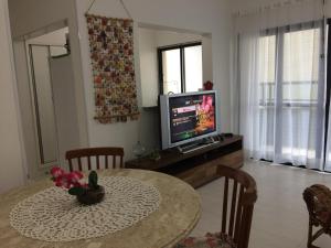 乌巴图巴Apartamento 2 Quartos Vista Mar的客厅配有桌子和电视