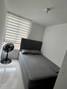 库库塔Acogedor apartamento tres habitaciones的窗户客房内的小床