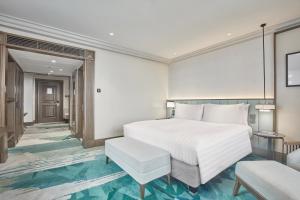 马尼拉Holiday Inn Manila Galleria, an IHG Hotel的卧室配有白色的床和椅子