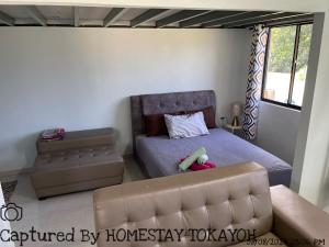 哥打巴鲁Homestay Studio TOKAYOH的一间带床和沙发的小卧室