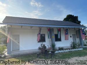 哥打巴鲁Homestay Studio TOKAYOH的一座白色的小房子,上面有美国国旗