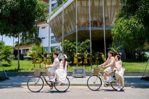 会安Bellerive Hoi An Resort and Spa的一群人在建筑物前骑车