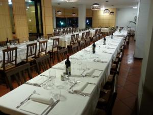 菲利内瓦尔达诺托斯卡纳酒店的餐厅里一排带葡萄酒瓶的桌子
