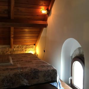 焦维纳佐Casa Torre Di Mactheus Petraro的一间卧室设有一张床和一个拱形窗户