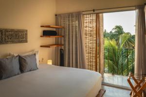 埃尔库约Casa Mia El Cuyo Eco Beach Boutique Hotel的一间卧室设有一张床和一个大窗户