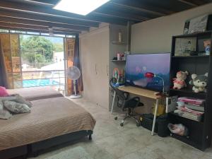 伊瓦格AKUARELA APARTAMENTOS CAMPESTRES Ibagué的一间卧室配有一张床和一张带电脑的书桌