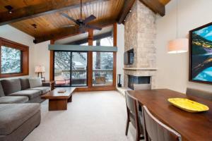 阿斯潘3 Bedroom Mountain Residence In The Heart Of Aspen With Amenities Including Heated Pool, Hot Tubs, Game Room And Spa的带沙发、桌子和壁炉的客厅