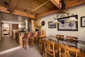 阿斯潘3 Bedroom Mountain Residence In The Heart Of Aspen With Amenities Including Heated Pool, Hot Tubs, Game Room And Spa的用餐室以及带玻璃桌和椅子的厨房