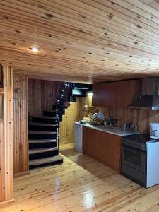 KoutsodímosTraditional Wooden Apartment的一间带木墙和木地板的厨房以及楼梯