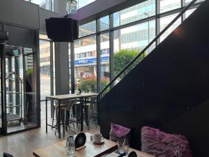 伯明翰B&B HOTEL Birmingham Centre的餐厅设有桌椅和大窗户。