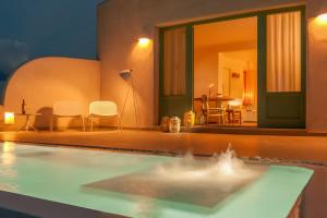 阿克罗蒂里海王星豪华套房酒店的客厅设有游泳池,配有桌椅