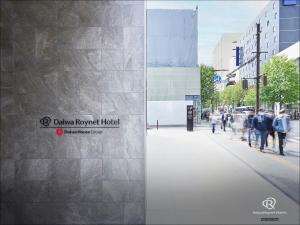 仙台Daiwa Roynet Hotel Sendai Nishiguchi PREMIER的一群人沿着建筑旁边的人行道走