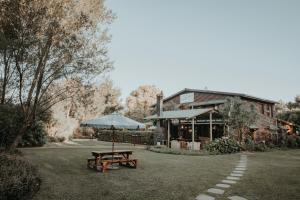 斯托姆勒菲Storms River Forest Lodge的大楼前的野餐桌和雨伞