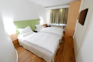 斯德哥尔摩早安希斯塔酒店的卧室配有白色大床和白色枕头