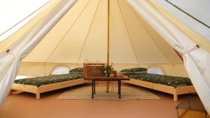 Sicignano degli AlburniGlamping Di Palma的帐篷配有三张床和一张桌子