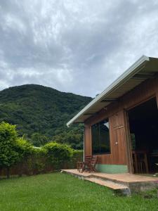 蒙泰韦尔德哥斯达黎加Casitas de Montaña Cabuya的小木屋,配有桌子和长凳,位于草地上