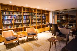 加舒恩Felbermayer Hotel & AlpineSpa-Montafon的图书馆配有桌椅和书架