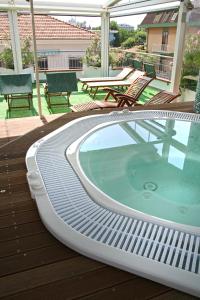里米尼卡迪兹酒店的甲板上的热水浴池配有椅子和桌子