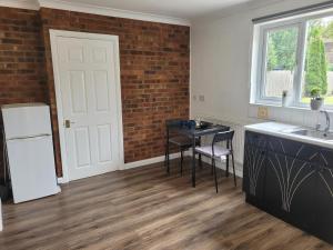 卢顿Luton City Escape - Modern 1BR Apartment的厨房配有白色冰箱和桌子