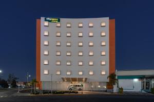 阿瓜斯卡连特斯City Express Junior by Marriott Aguascalientes Centro的停在前面的带货车的建筑