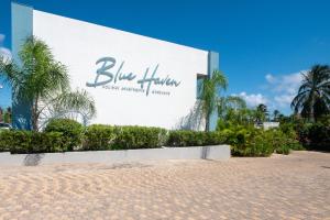 基督教堂市Blue Haven Holiday Apartments的一座带蓝色疗法标志的大型建筑