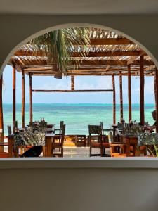 江比阿HA Beach Hotel Zanzibar的海景餐厅设有桌椅