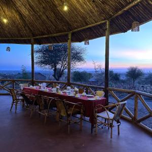 MakuyuniMaasai Eco Boma & Lodge - Experience Maasai Culture的一张带椅子的餐桌,享有荒野的景色