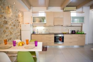 罗希姆诺AC Homes Christos的厨房配有白色的桌子和绿色的椅子