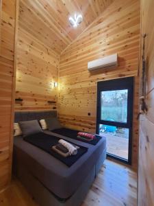 乌尔齐尼modernes Holzhaus, Cabin, auf dem Fluss, wenige Meter zum Meer的小木屋内一间卧室,配有一张床