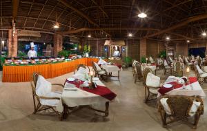 可瓦兰索玛马娜西拉姆度假村的餐厅设有白色的桌椅和柜台