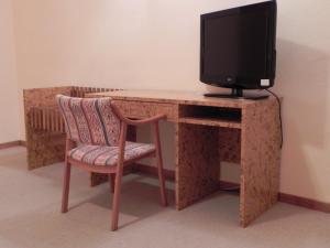 埃尔蒂恩夫洛托洛斯迪谷逸三都酒店的一张带电视和椅子的电脑桌