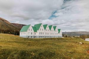 劳加尔瓦特恩Héradsskólinn Historic Guesthouse的田野上一座白色的大建筑