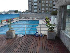 科尔多瓦Temporario en Villa Sol的甲板上拥有两株盆栽植物的游泳池