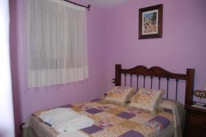 布维翁Casa El Rincón del Ángel的一间卧室配有一张紫色墙壁和窗户的床