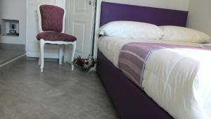都灵曼萨达帕拉提公寓的一间卧室配有一张大床和一把椅子